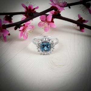 cushion kesim blue topaz merkez tasli ve pirlanta detayli vintage yuzuk dekorlu zemin uzerinde