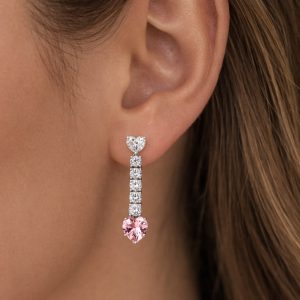 ustte beyaz kalp taş ve altta pembe kalp taş bulunan sallantılı küpe kulakta duruşu