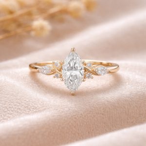 markiz kesim merkez pirlanta tektaşli minimal markiz ve yuvarlak pirlanta detayli vintage yuzuk dekorlu zemin uzerinde