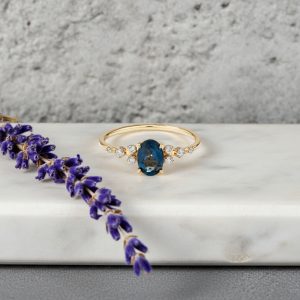 oval kesim london blue topaz merkez tasli ve pirlanta detayli vintage yuzuk dekorlu zemin uzerinde