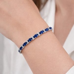 kadın bileğinde 10 karat oval kesim safir ve 0,50 karat pırlanta taşlı beyaz altın fantezi bileklik