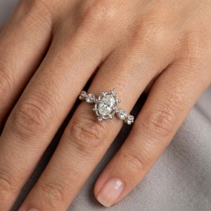 parmak üzerinde sergilenen oval kesim vintage pırlanta yüzük, merkez taş ve yan taş detaylarıyla şık ve zarif görünüm