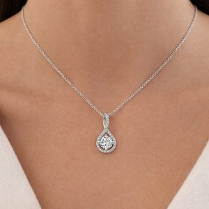 kadın boynunda beyaz altın yuvarlak kesim pırlanta kolye damla çerçeveli zarif görünüm