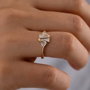 kalp atışı çizgisini andıran sarı altın form ve geometrik pırlantalardan oluşan tasarım yüzüğün elde kullanım görünümü